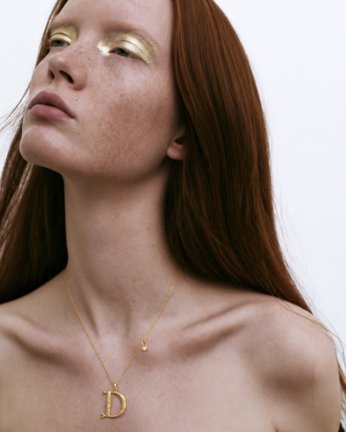 Modèle portant le collier initial D en or