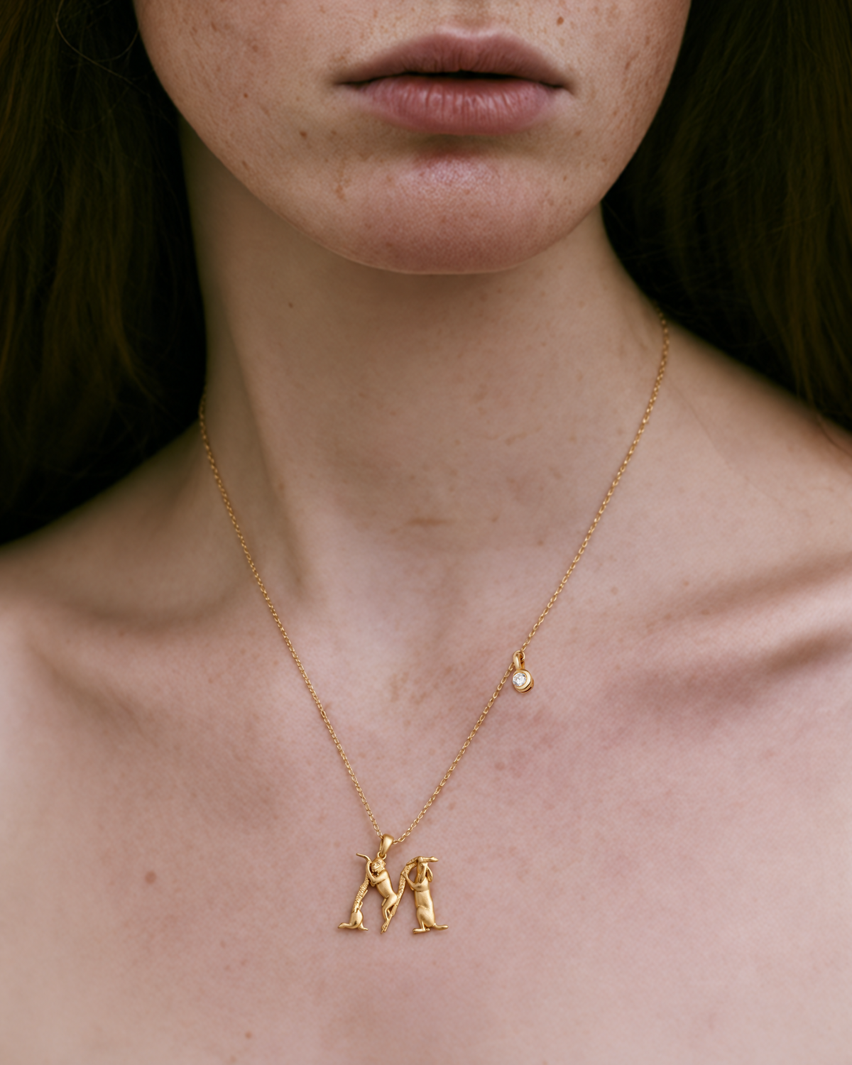 Model wearing the gold M initial necklace