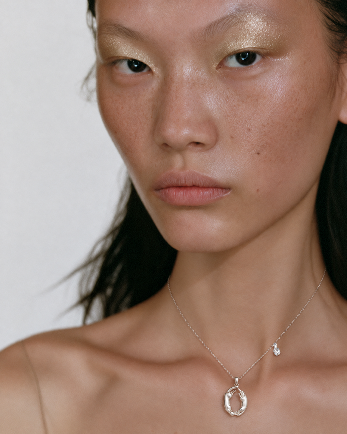 Modèle portant le collier initial O en or