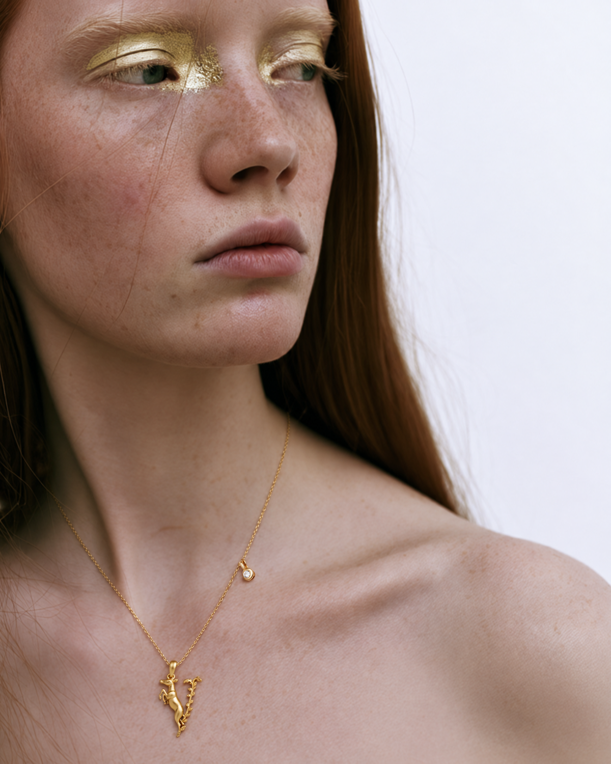 Modèle portant le collier initial V en or